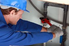 a plumber working on the side of a wall