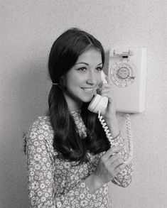 a woman is talking on the phone and smiling