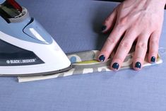 a woman's hand on top of a ironing board