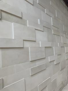 a white wall that has some tiles on it