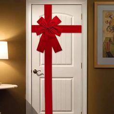 a white door with a red ribbon on it and a light next to it that is turned on