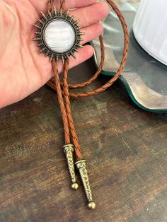 a person holding onto a brown cord with a sunburst on it and some other items in the background