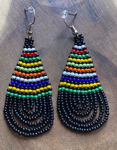 These handmade beaded earrings are truly unique. Each one is hand made with a rotating striped pattern. These earrings are available in a multitude of colors -making them perfect for any outfit! Whether it's dressing up a jean jacket or adding a unique texture to a LBD, there's no way you can go wrong with these earrings! We have given each design a name in honor of our favorite people! Please note that colors may vary a bit by pair as no two are exactly alike Casual Multicolor Teardrop Earrings, Handmade Casual Beaded Earrings, Handmade Black Casual Earrings, Handmade Casual Black Earrings, Casual Handmade Beaded Earrings, Casual Multicolor Dangle Beaded Earrings, Casual Multicolor Beaded Dangle Earrings, Casual Multicolor Earrings For Festivals, Casual Multicolor Festival Earrings