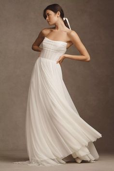 a woman in a white dress is posing