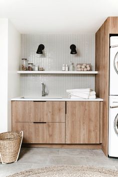 a washer and dryer sitting next to each other in a room with wooden cabinets