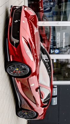 a red sports car parked in front of a building