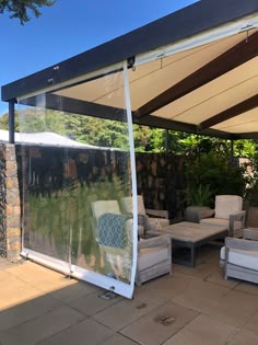 a covered patio area with couches and chairs