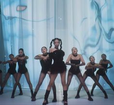 a group of young women in black outfits