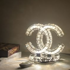 a chanel light sitting on top of a table next to a remote control