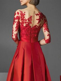 the back of a woman's dress with red flowers on it and lace detailing