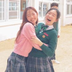 two young women are hugging each other outside