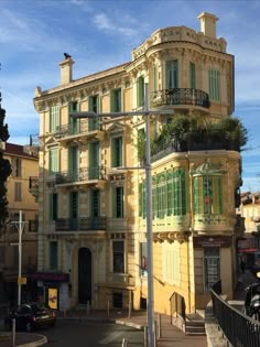 an old building with green shutters and balconies on the top floor is shown