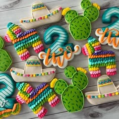 decorated cookies are arranged on a table with the word fiesta written in large letters and cactus decorations