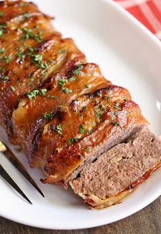 meatloaf on a white plate with fork and knife