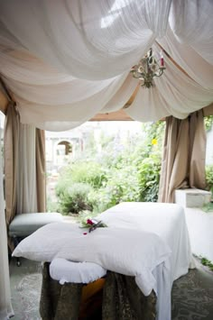 a white bed sitting under a canopy in a bedroom