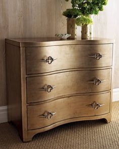 a wooden dresser with three drawers and a potted plant on top