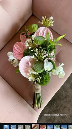 a bouquet of flowers sitting on top of a pink couch next to an instagram page