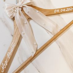 two wooden wedding stirs with personalized names on them and bows tied to them