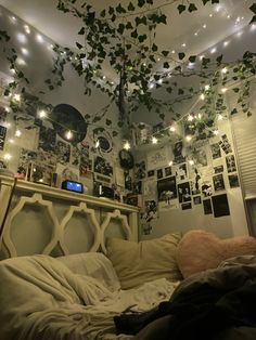 an unmade bed with lots of lights hanging from the ceiling and ivy growing over it