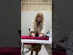 a woman ironing clothes on an ironing board in a room with other equipment