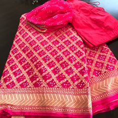 Pink Banaras Bandhni Khaddi Georgette Handloom Saree With A Bell Sleeve Designer Blouse ! Look Stunning And Captivating On This Beautiful Pure Pink Bandhej Banaras Saree. Saree Is Adorned With Gorgeous Gold Zari Jaal Blended With Tie And Die Technique. Ready To Ship Available! 2-3 Days Within Usa! Contact Us For More Details! Pink Silk Traditional Wear With Gota Work, Fitted Pink Traditional Wear With Gota Work, Pink Silk Traditional Wear With Chikankari Embroidery, Pink Choli With Gota Work For Transitional Season, Transitional Pink Choli With Gota Work, Silk Pink Sharara With Cutdana, Pink Silk Sharara With Cutdana, Traditional Pink Silk Anarkali Set, Pink Silk Saree Set