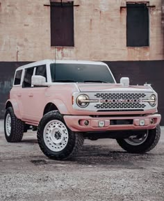 a pink truck parked in front of a building