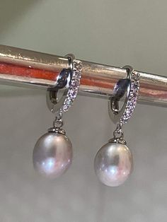 These are the earrings Kate Middleton Wears casually, We replicate them in detail, from pearl shape & size They are made of natural gray Pearl (akoya) with Melee Sized Diamonds Sterling Setting. 925 Stamp setting. Exceptional quality pearl with beautiful luster and brilliant nacre. You can see reflection off the pearl. We also pay attention to detail. Like Kate's earrings... You will also notice there's no hole on the bottom of the pearl, (no posts stick out of bottom like you see on many lo Elegant Oval Pearl Earrings With High Luster, Elegant Tahitian Pearl Earrings For Wedding, Elegant Silver Diamond Earrings With Pearl Drop, Tahitian Pearl Round Earrings For Wedding, Round Tahitian Pearl Earrings For Wedding, Luxury Oval Pearl Drop Earrings, Silver Akoya Pearl Dangle Earrings, Classic White Gold Tahitian Pearl Earrings, Classic Tahitian Pearl Earrings In White Gold