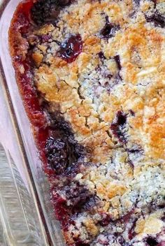 a blueberry cobbler in a glass dish on a wooden table