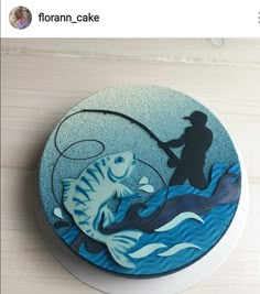 there is a cake decorated with a fisherman and fish in the water on top of a table