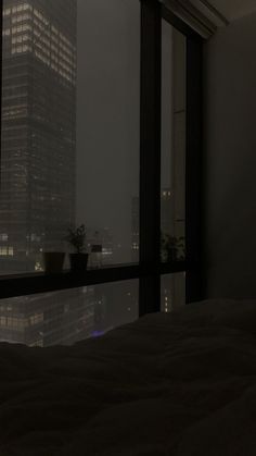 a bedroom with a view of the city at night