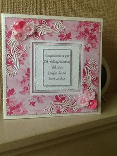 a pink and white card with flowers on it