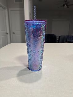 a purple and blue glass sitting on top of a table