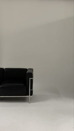 a black chair sitting in front of a white wall