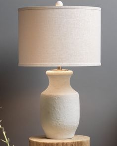 a white lamp sitting on top of a wooden table