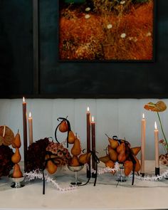 a table topped with lots of candles and fruit