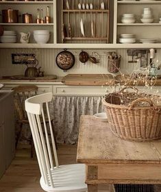 a wooden table topped with a basket next to a white kitchen sink and stove top oven