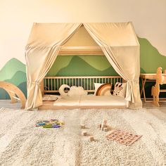 a child's bedroom with a tent bed and toys on the floor in front of it