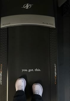 a person standing on top of a treadmill with their feet propped up against the machine