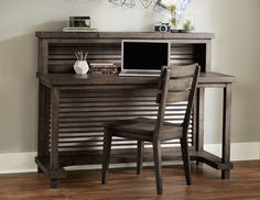 a wooden desk with a computer on top of it and a chair next to it