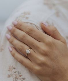 a woman's hand with a diamond ring on her finger