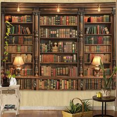 a large book shelf filled with lots of books next to a table and lamp on top of a hard wood floor