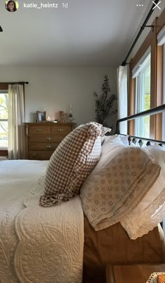 a bed with white sheets and pillows in a bedroom next to two windows on either side of the bed