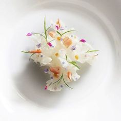 a white plate topped with flowers on top of a table