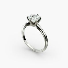 a white gold engagement ring with a single diamond in the center, on a white background