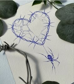 a piece of paper with a heart drawn on it next to leaves and barbed wire