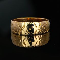 two gold wedding bands with black bears on them