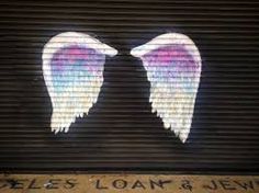 two angel wings painted on the side of a garage door