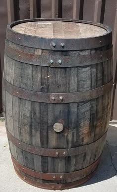 an old wooden barrel sitting on the sidewalk