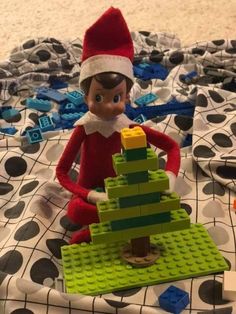 an elf with a lego christmas tree on the bed