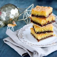 three pieces of cake sitting on top of a white plate next to a silver ornament